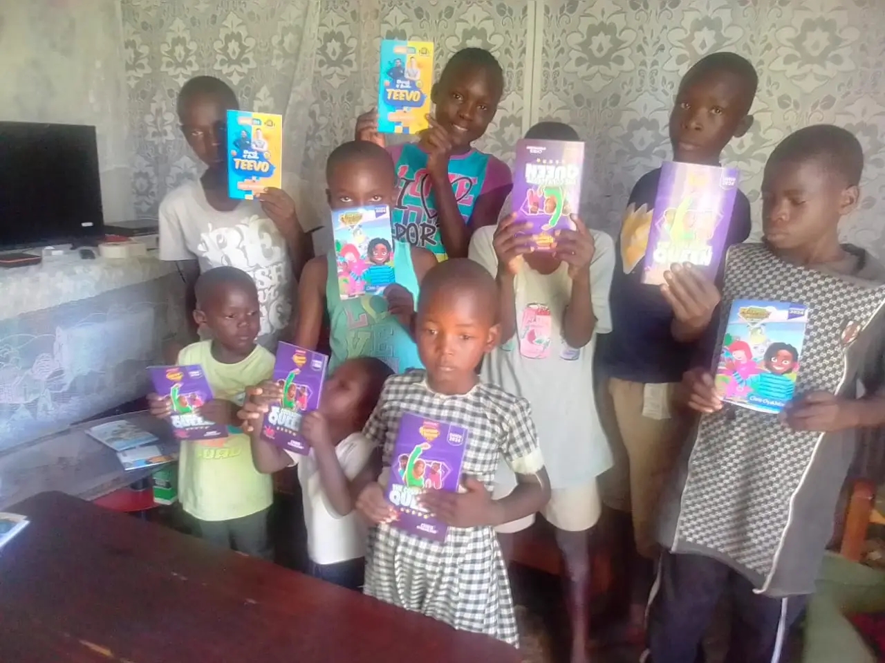 A group of children displaying ministry resources together indoors.